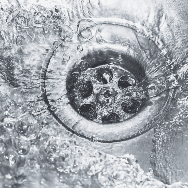 a pool of water draining down a kitchen sink