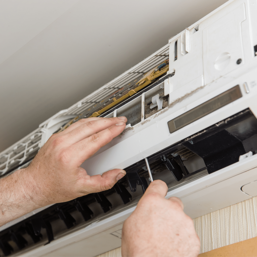 hands of a service technician adjusting a ductless ac unit during repair services