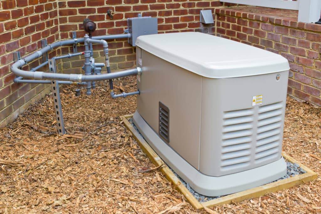 a whole home generator installed in the yard of a red brick home