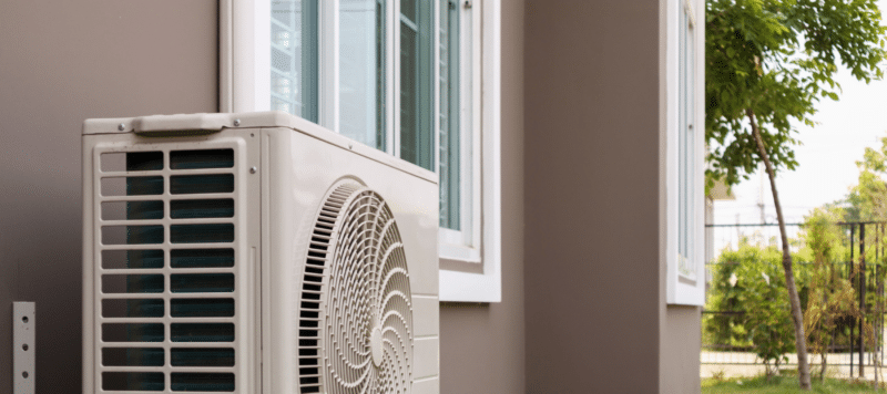 an outdoor ac system installed onto the wall of a home